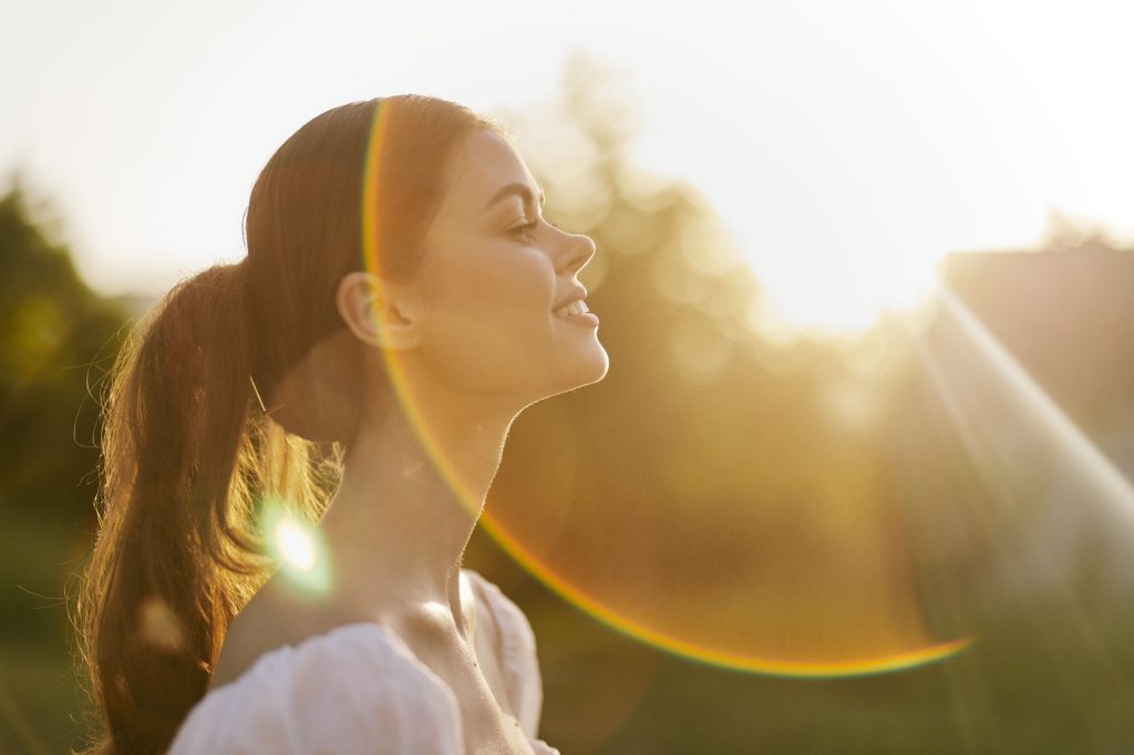 Woman smiling in the sun with strong healthy teeth