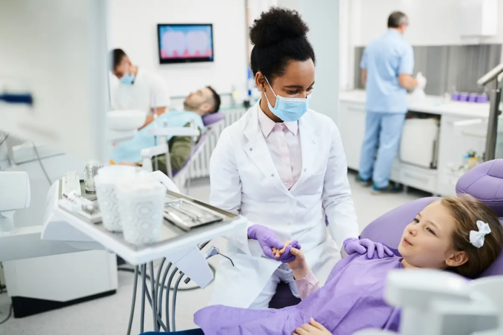 A pediatric patient sits in the dental chair for her preventive dentistry checkup.